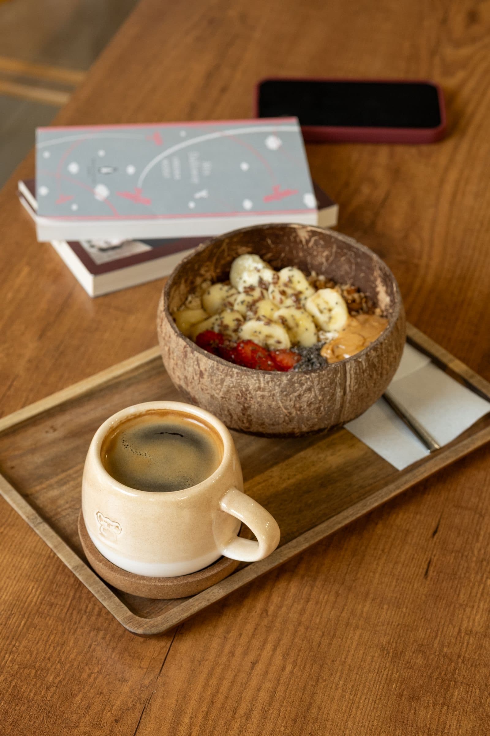 A breakfast of a fruit bowl and estate coffee on a wooden tray