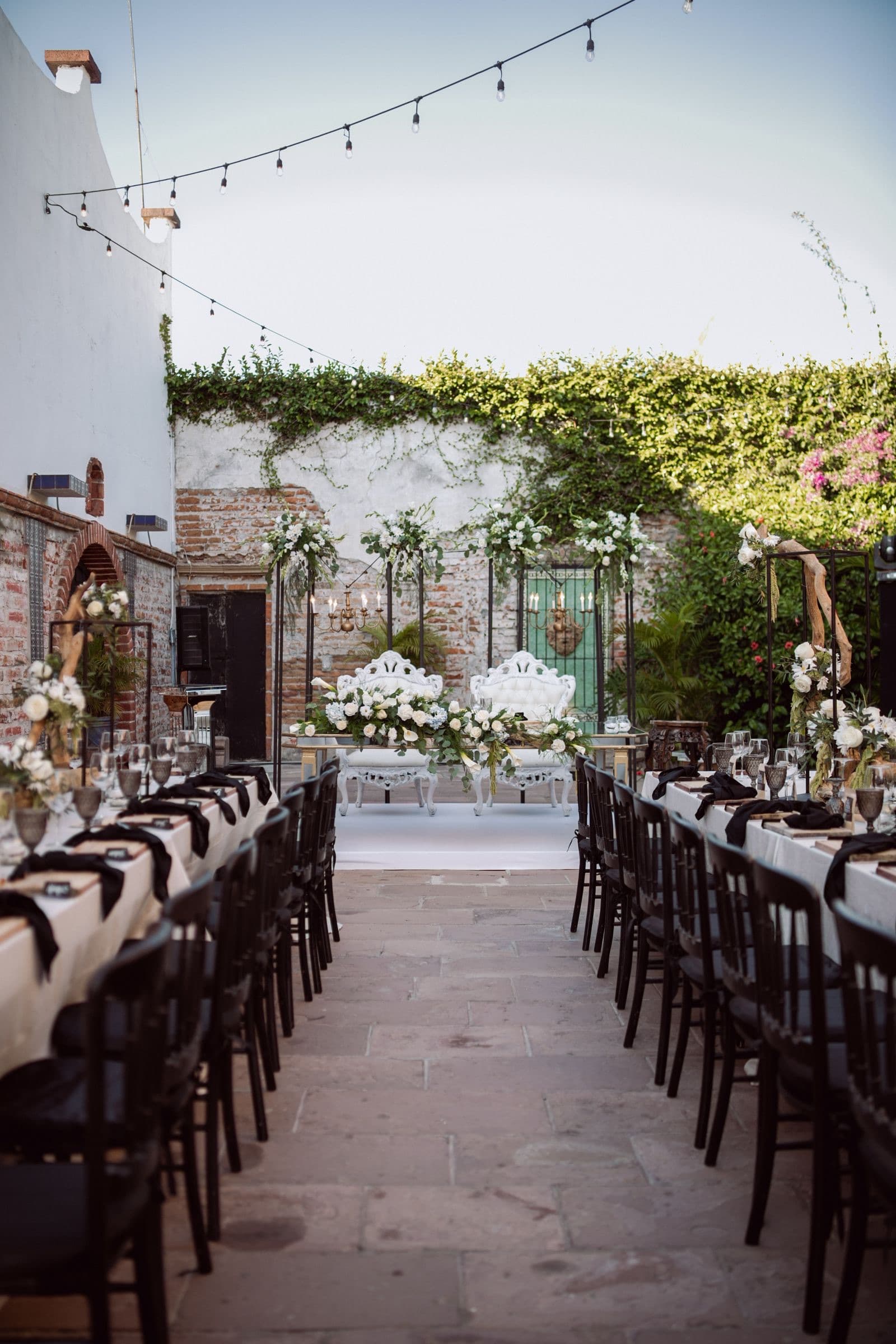 Long tables with white flowers set for a garden wedding dinner